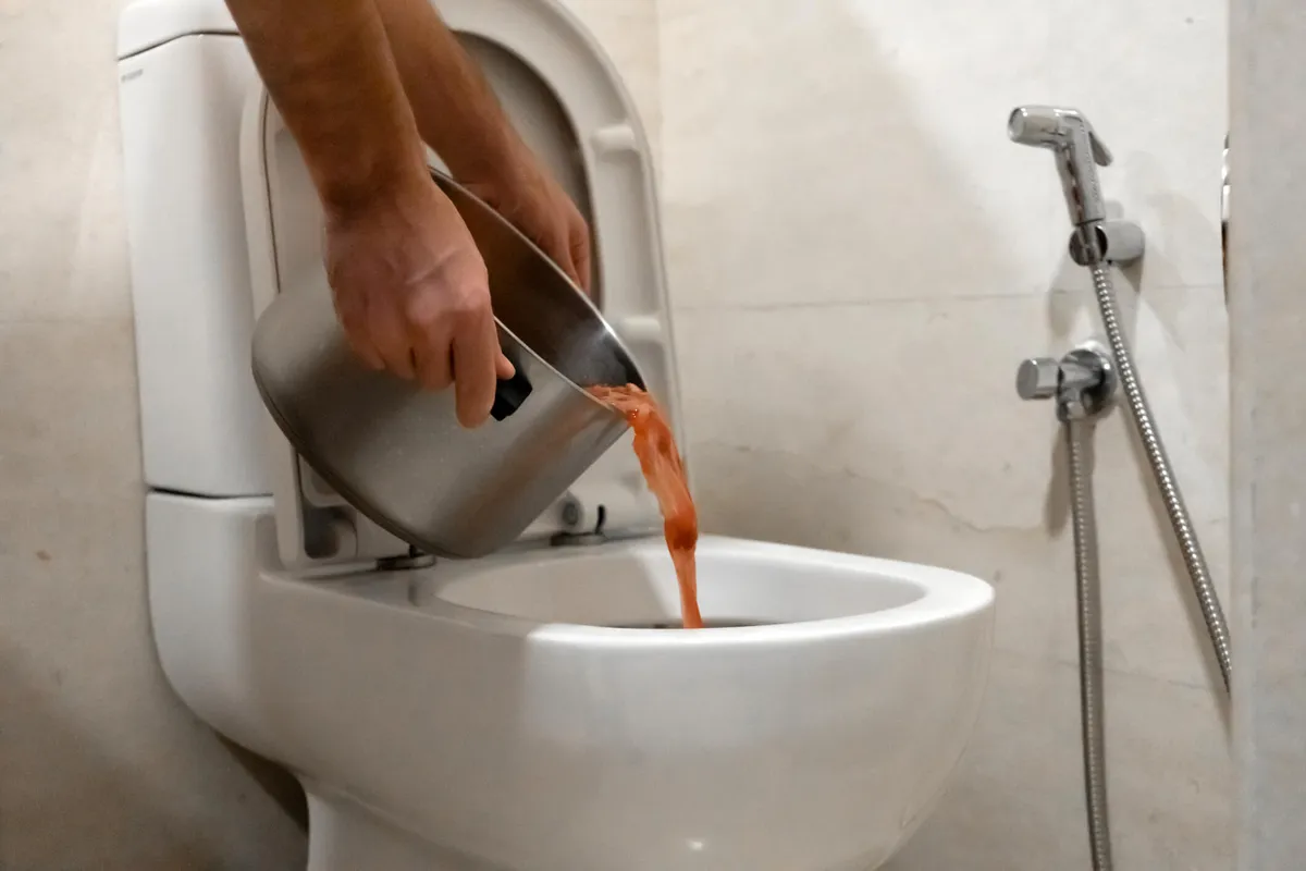 Pessoa despejando produto dentro do vaso sanitário